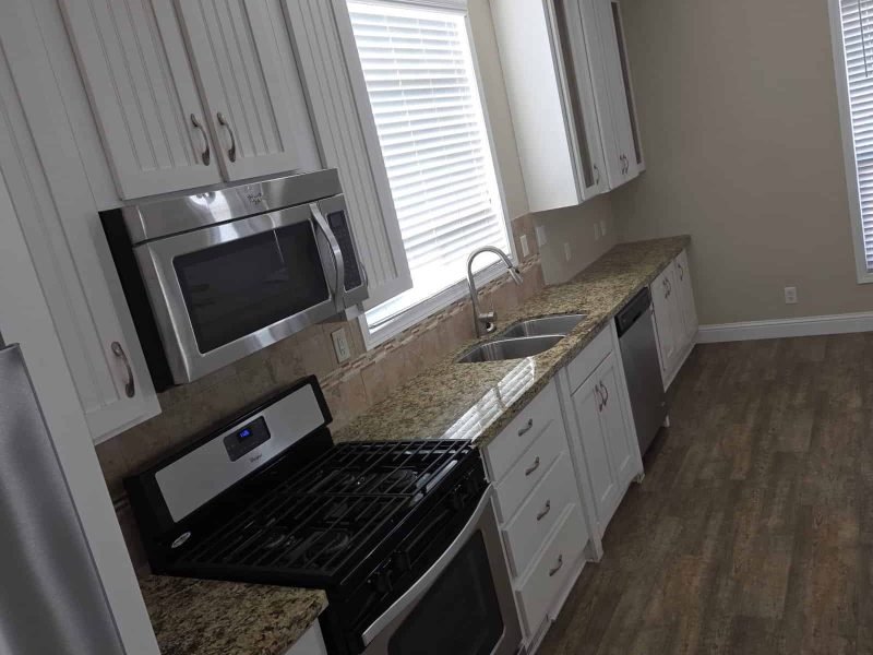 Bright and spacious kitchen with white cabinets and granite countertops, perfect for family living and entertaining.