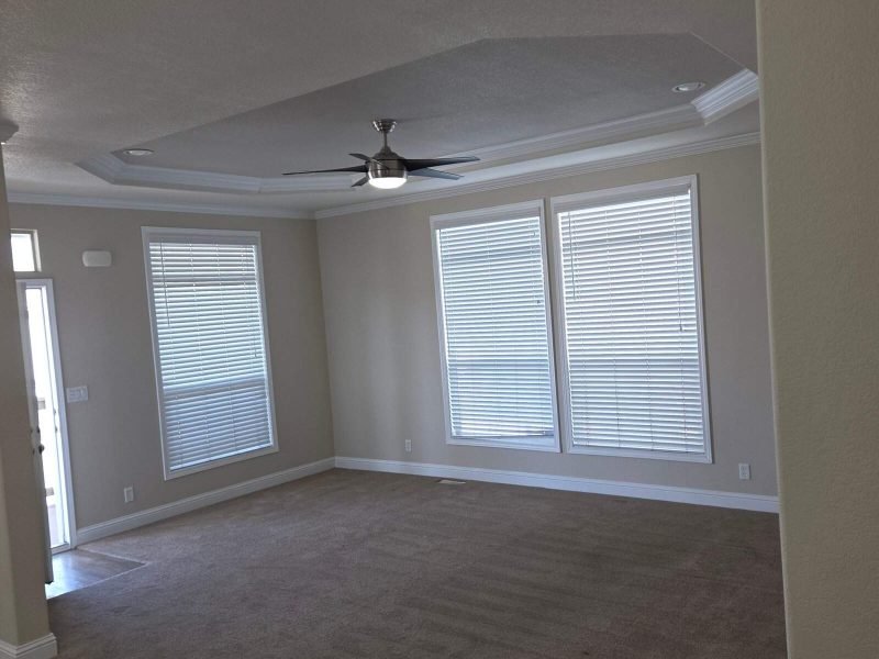 Bright living space with new windows and stylish ceiling fan for comfort.